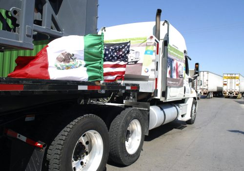 A truck of the Mexican company Olympics bearing Mexican and U.S. flags approaches the border crossing into the U.S., in Laredo October 21, 2011. The Mexican transport truck carrying a ten-foot drill on Friday crossed into the United States and punitive tariffs were suspended as the two nations fulfilled a promise to resolve a longstanding trade dispute.